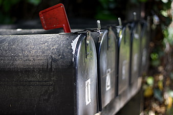 Row of black mailboxes with red flag raised