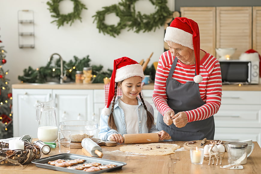 Grandmother and granddaughter baking Christmas cookies in kitchen