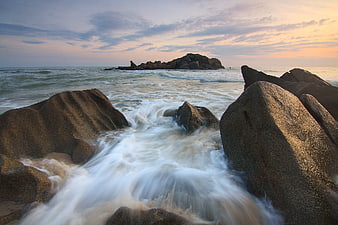 Long Exposure Ocean Waves Crashing on Granite Rocks at Sunset
