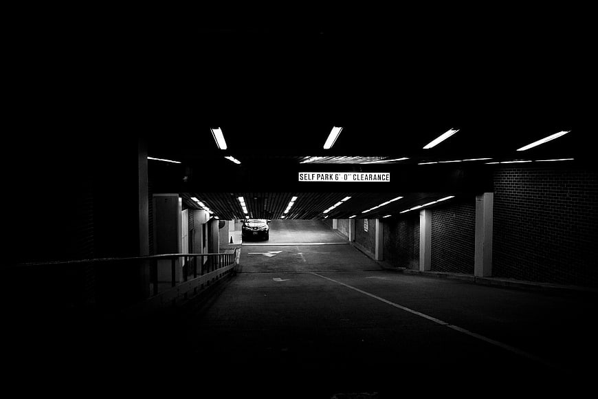 Dark monochrome parking garage with overhead lights