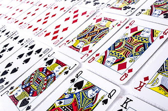 Close-up of playing cards arranged in a diagonal row on a white background