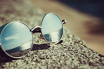Round Sunglasses on Rock Reflecting Beach Ocean