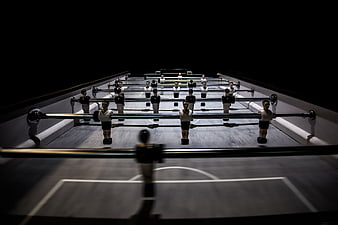 Dramatic foosball table with players in dark lighting