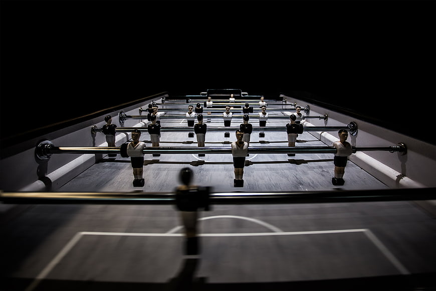 Dramatic foosball table with players in dark lighting