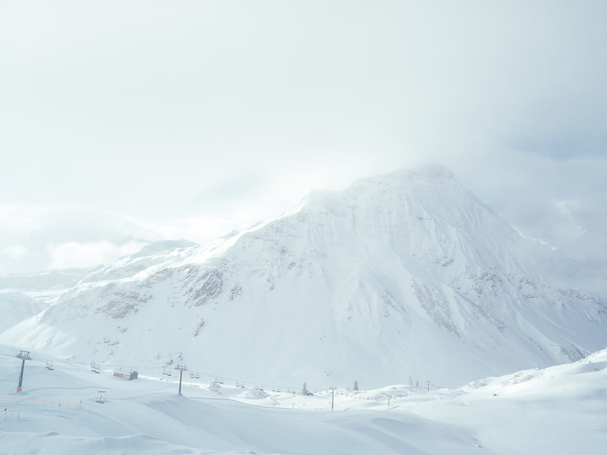 Snowy mountain peak with ski lifts in winter landscape