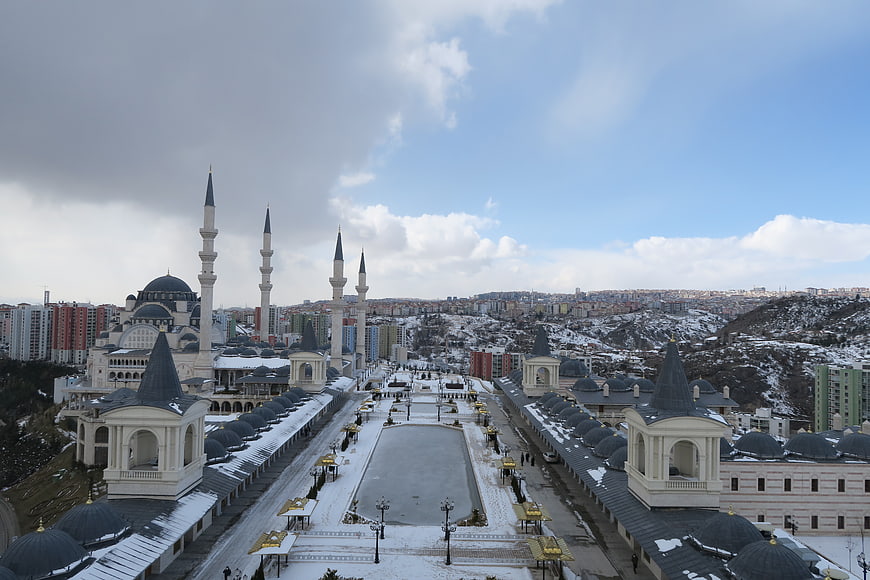 Snowy Mosque Complex with Minarets and Cityscape