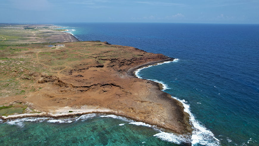 Aerial View of Rocky Coastal Peninsula with Turquoise Ocean Waves