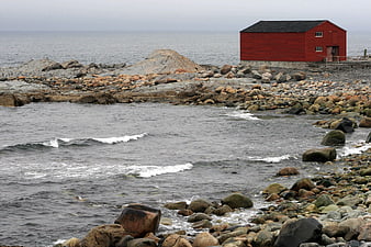 Red Boathouse on Rocky Coastal Shoreline