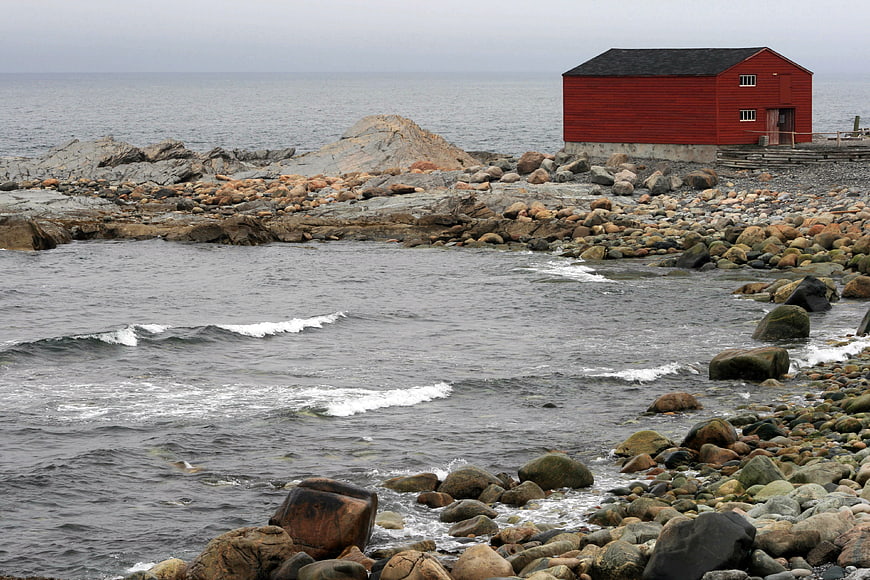 Red Boathouse on Rocky Coastal Shoreline