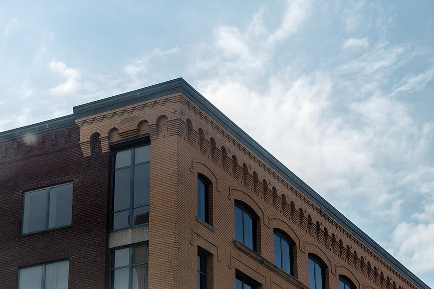 Low Angle View of Brick Building Corner Against Blue Sky