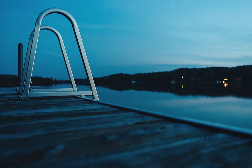 Metal Dock Ladder at Dusk on Calm Lake