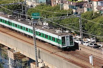 Green and white subway train on elevated tracks in Seoul