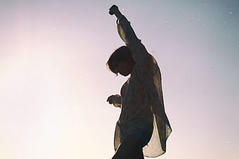 Silhouette of Woman Dancing Against Bright Sky