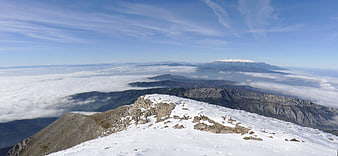 Panoramic Snowy Mountain Peak Above Sea of Clouds
