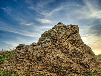Rugged Rock Formation Under Dramatic Blue Sky