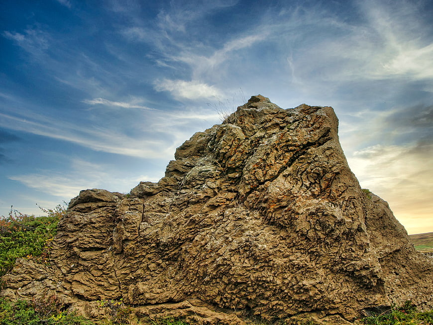 Rugged Rock Formation Under Dramatic Blue Sky