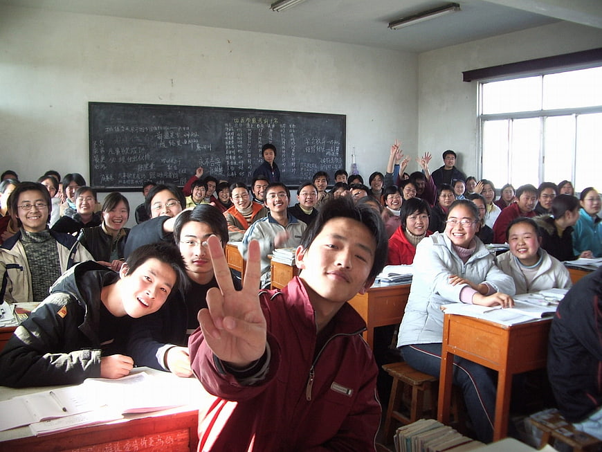 Happy Asian Students in Classroom Making Peace Sign