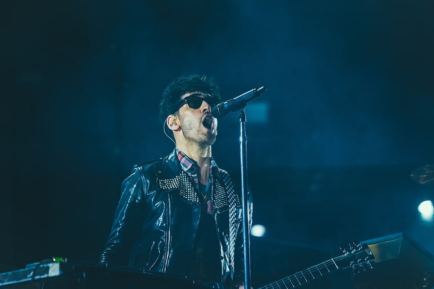 Male Rock Singer Performing on Stage with Guitar