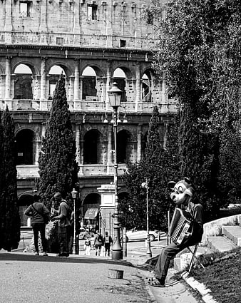 Street musician in mascot costume playing accordion near Colosseum Rome