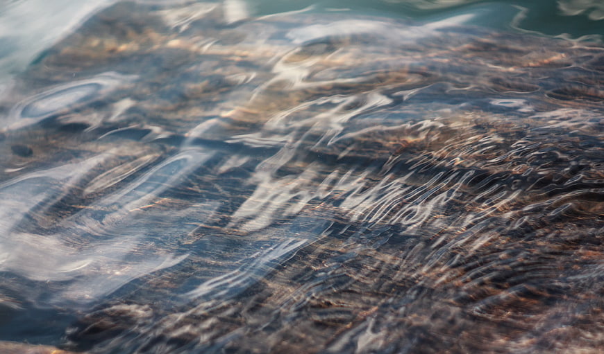 Abstract Close-Up of Clear Water Ripples Over Rocks