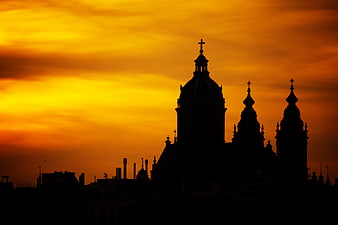 Silhouette of Amsterdam Cathedral Against Vibrant Orange Sunset Sky