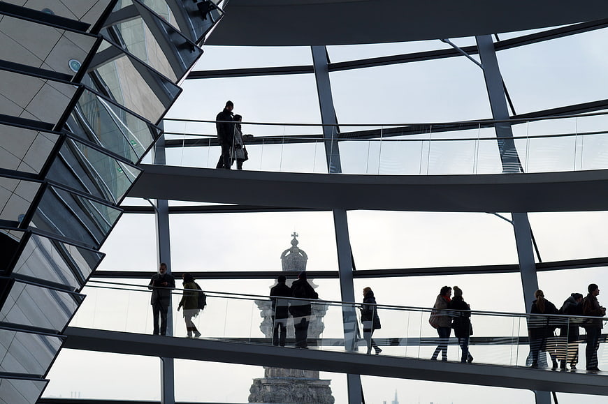 Silhouettes of tourists walking on Reichstag dome spiral ramp