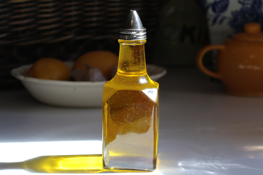 Golden Olive Oil Bottle In Kitchen Setting With Lemons