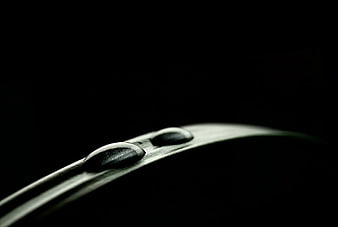 Macro water droplets on green leaf edge against black background