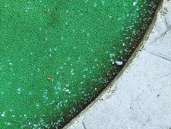 Close-up of green artificial turf and concrete edge