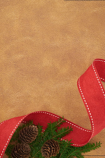 Christmas pine branches and red ribbon on gold leather background