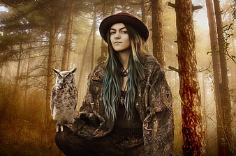 Fantasy portrait of woman with owl in misty forest
