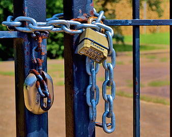 Rusty Chains and Padlocks Securing a Blue Metal Gate