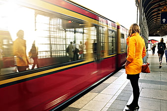 Woman in Yellow Coat Waiting for Red Train