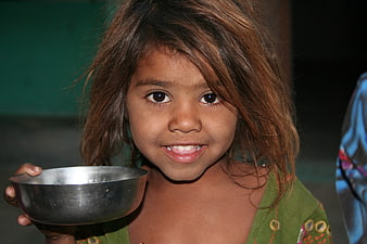 Portrait of smiling young girl holding metal bowl