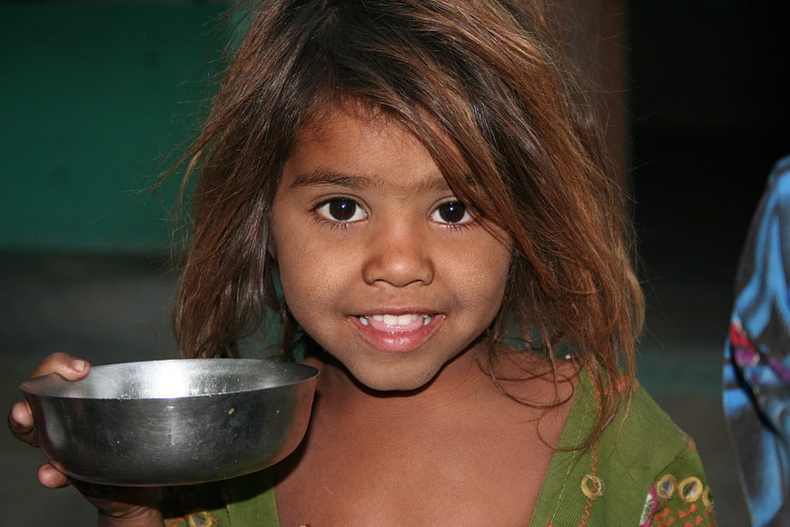 Portrait of smiling young girl holding metal bowl