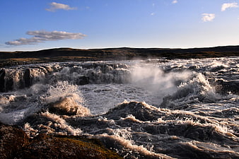 Powerful waterfall cascading over rocky terrain in Iceland