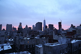New York City skyline at sunset with snow-covered rooftops