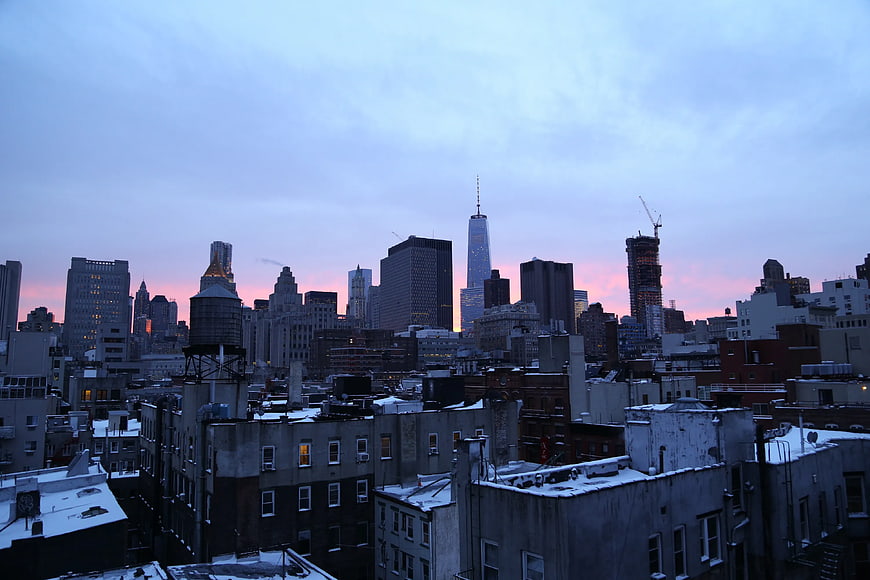 New York City skyline at sunset with snow-covered rooftops