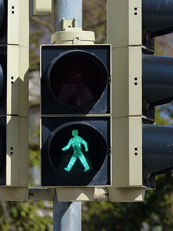 Green pedestrian walk signal on urban traffic light