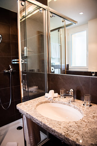Modern bathroom interior with granite countertop and glass shower