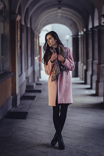 Woman in Pink Coat Walking Under Arched Portico