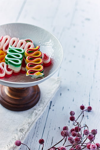 Colorful Ribbon Candy in White Bowl with Frosted Berries