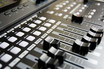 Close-up of professional audio mixing console sliders and buttons