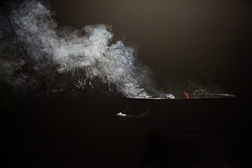 Dramatic Smoke Rising From Charcoal Grill Against Dark Background