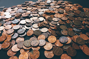Pile of US Pennies and Coins on Dark Surface