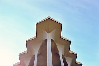 Modern geometric architecture against a clear blue sky