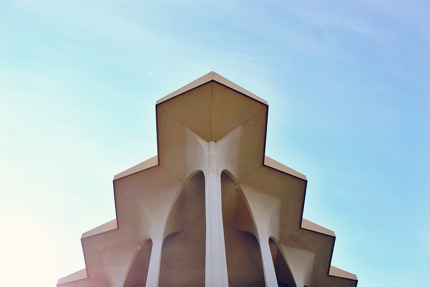 Modern geometric architecture against a clear blue sky