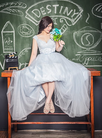 Bride in Blue Gown Sitting on Bench with Chalkboard Background