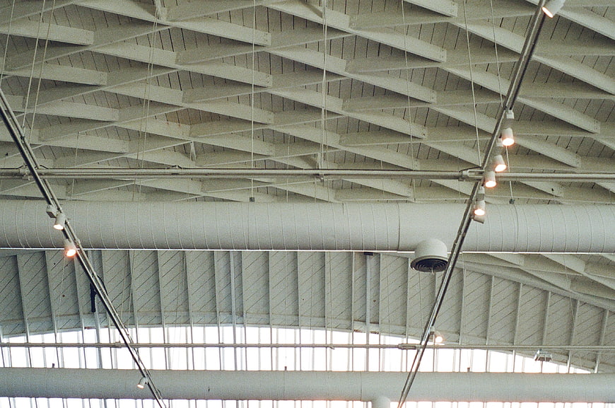 Industrial ceiling with white beams, ducts, and track lighting