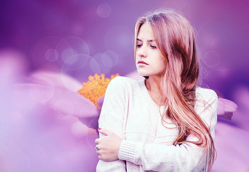 Sad woman with pink hair against purple flower background